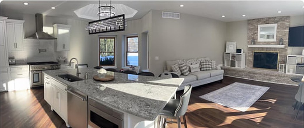 Kitchen after: white cabinetry, granite island, open living space