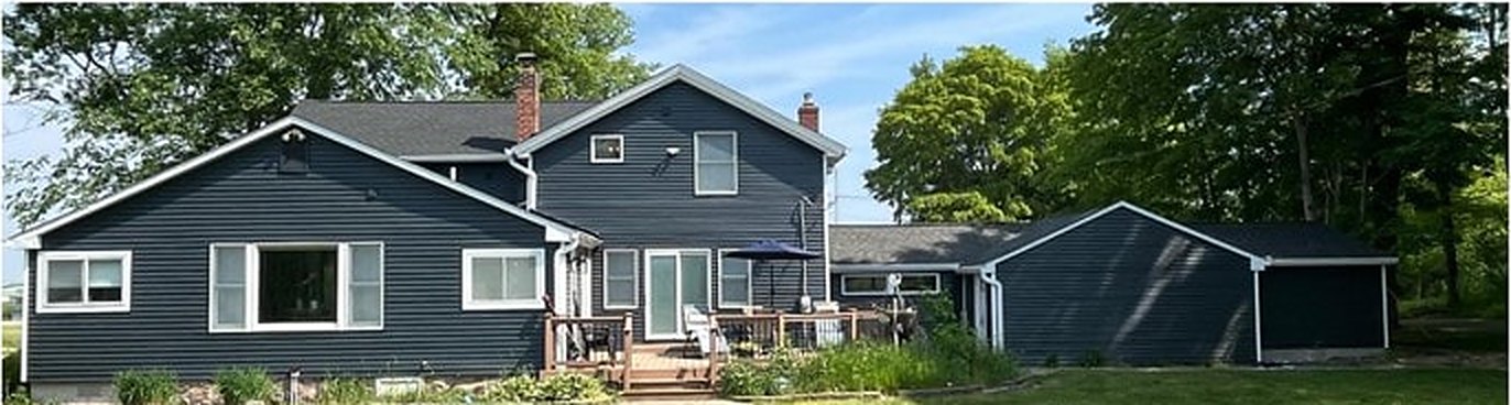 Two-story home repainted in deep charcoal with white trim