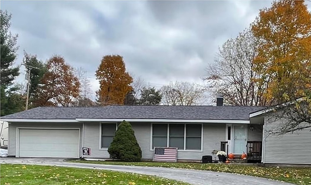 The same home before, with worn white siding
