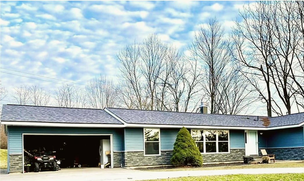 A Michigan home after new blue siding and stone veneer, a HomePro job